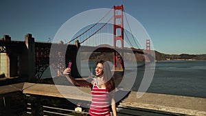 Woman taking selfie with Golden Gate Bridge