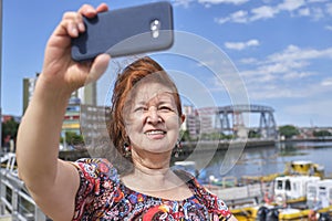 Woman taking a selfie with her cell phone in La Boca, Buenos Aires, Argentina