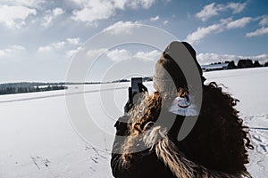 Woman taking a selfie of her surrounded by a scenic winter scenery