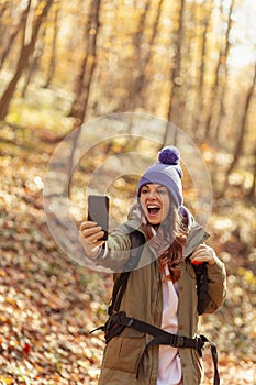 Woman taking a selfie while hiking in the forest