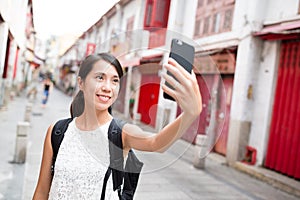 Woman taking selfie by mobile phone photo