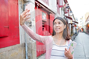 Woman taking selfie by mobile phone in Macao photo