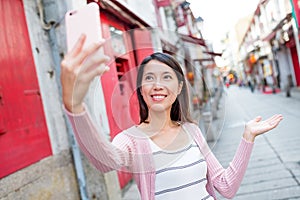 Woman taking selfie with mobile phone in Rua da Felicidade of Ma photo