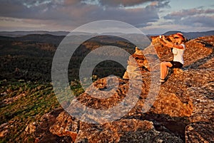 Woman taking a selfie with phone in mountain landscape