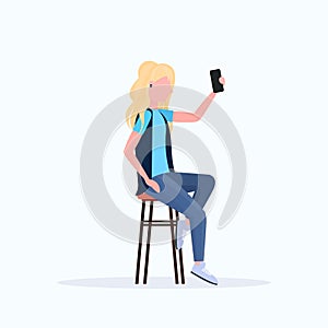 Woman taking selfie photo on smartphone camera blonde female cartoon character sitting on chair posing on white