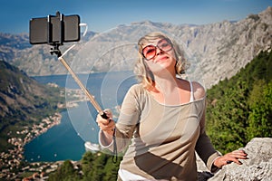 Woman taking selfie picture on landscape background using photo