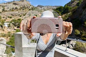 Woman taking selfie picture with mobile phone at mountains