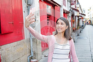 Woman taking selfie in Rua da Felicidade of Macao photo