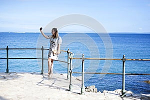 Woman taking selfie by the sea