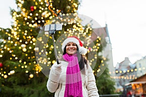 Woman taking selfie with smartphone at christmas