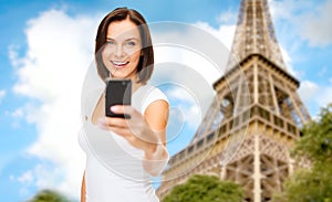 Woman taking selfie with smartphone in paris