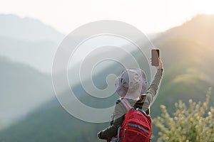 Woman taking selfies while hiking up a mountain