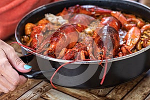 Woman taking Spanish paella with lobster. Close up