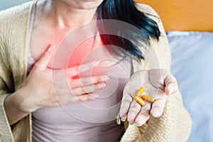 Woman taking turmeric pill, or curcumin herb medicine for GERD, treatment for heartburn from acid reflux disease