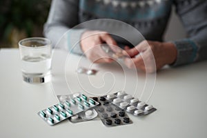 Woman taking various capsules and pills