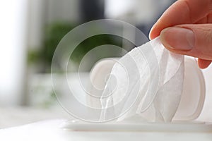 Woman taking wet wipe from pack on background, closeup