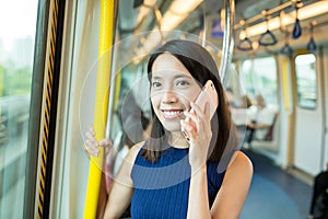 Woman talk to mobile phone inside train compartment