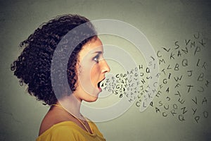 Woman talking with alphabet letters coming out of her mouth. Communication intelligence concept