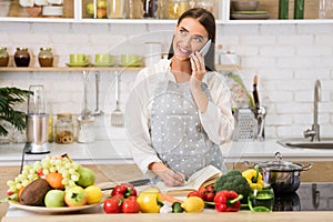 Woman talking on cellphone and writing new recipes