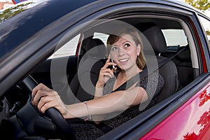 Woman talking happy on mobile phone while holding car steering wheel driving distracted