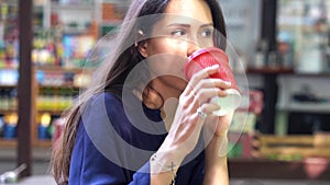 Woman talking on mobile cell phone and drinking from a red plastic cup