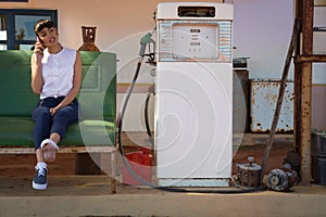 Woman talking on mobile phone at petrol pump station