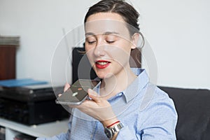 Woman talking on the phone with digital voice assistant
