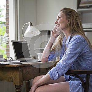 Woman talking on the phone at her home desk