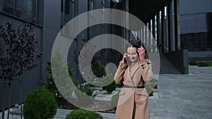 Woman talking phone outside in american style Business Center on the background