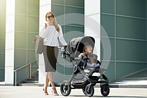 Woman talking on the phone and pushing baby stroller