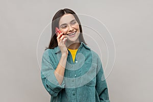 Woman talking phone and smiling, pleasant conversation with boyfriend, making appointment or date.