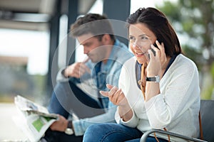 woman talking on phone while waiting for bus at busstop