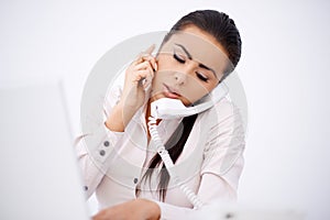 Woman talking by phones simultaneously photo