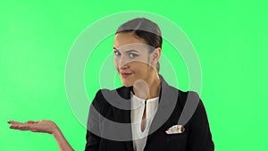 Woman talking and pointing side hand for something, copy space. Green screen