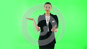 Woman talking and pointing side hand for something, copy space. Green screen