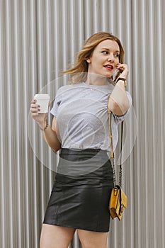 woman talking to her phone while drinking coffee