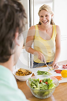 Woman Talking To Husband While Preparing meal