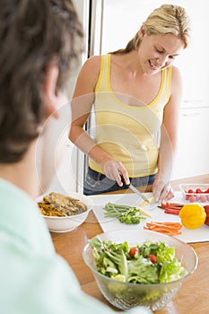 Woman Talking To Husband While Preparing meal