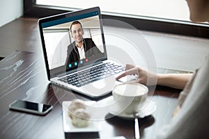 Woman talking to man in headphones via video call.