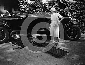 Woman talking to man working on car