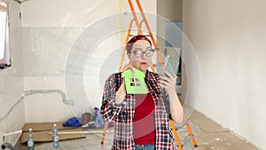 A woman talks on the phone, shows the keys to a new apartment where renovations