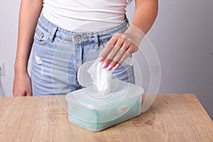 Woman in tank top take one wet wipes for cleaning hands from the disposable package - hygiene procedure and prevention of