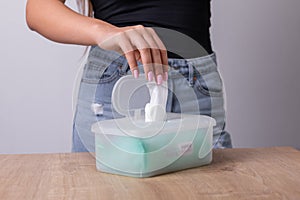 Woman in tank top take one wet wipes for cleaning hands from the disposable package - hygiene procedure and prevention of