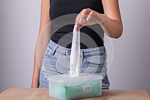 Woman in tank top take one wet wipes for cleaning hands from the disposable package - hygiene procedure and prevention of