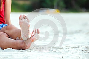 A Woman tanned legs on sand beach. Travel concept.