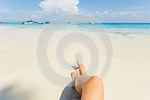 Woman tanned legs on sand beach. Travel concept. Happy feet in tropical paradise