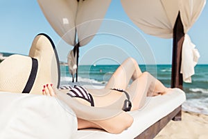 Woman tanning on the beach in her vacation