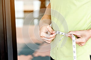 Woman with tape measure around waist