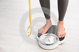 Woman with tape standing on scales , space for text. Overweight problem