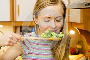 Woman tasting stir fry vegetable from pan